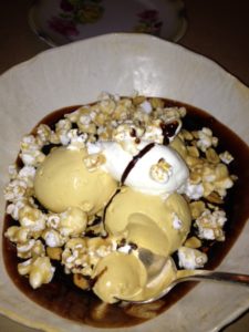 sundae starring salted caramel ice cream, candied peanuts and popcorn with whipped cream and chocolate sauce